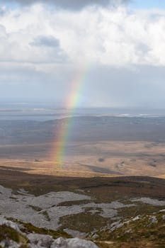 A stunning rainbow stretches across a rugged landscape, showcasing nature's beauty.