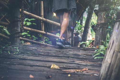 Woman Walking on Wooden Bridge
