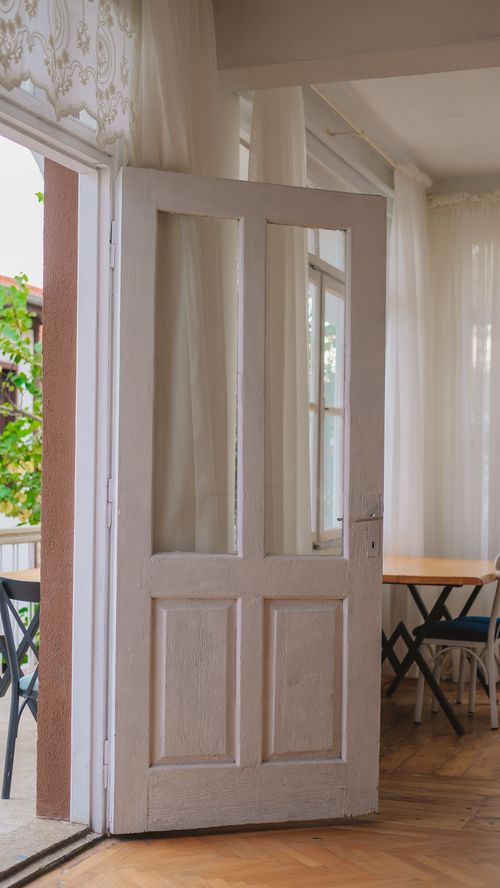 Free Charming indoor scene with an open wooden door leading to a cozy room with soft light. Stock Photo