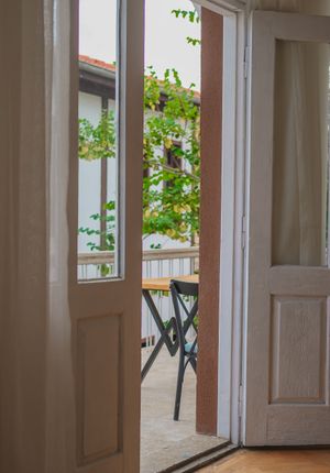 Open balcony door with outdoor seating, photo by Bilakis on Pexels