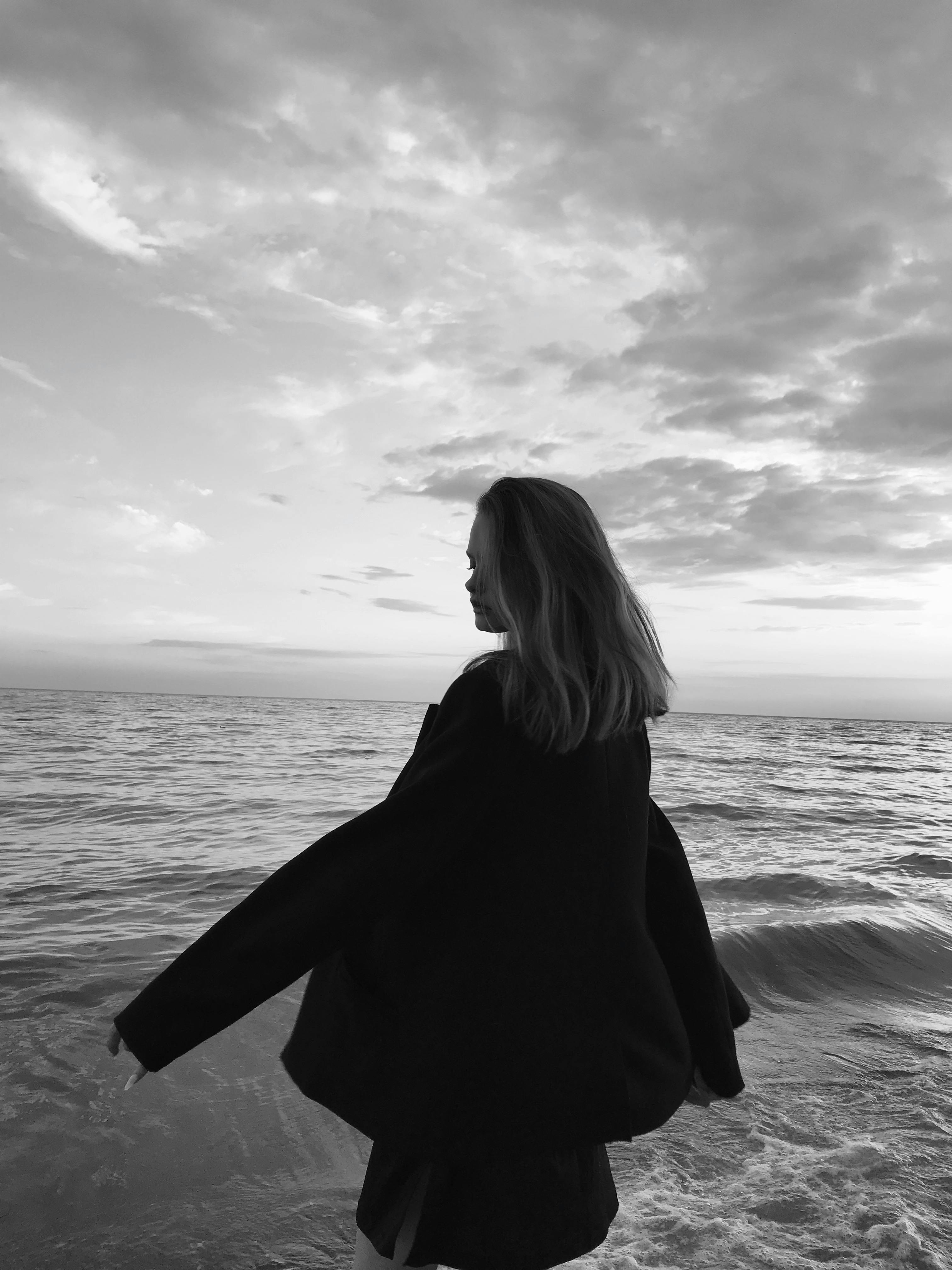 A peaceful moment captured as a woman strolls along the beach in Kherson, Ukraine at sunset.