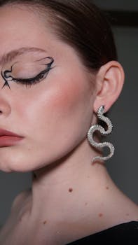 Detailed close-up portrait of a woman with artistic makeup and a snake-shaped earring.