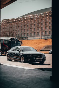 A sleek black Audi parked in an urban area, highlighting luxury and sophistication.