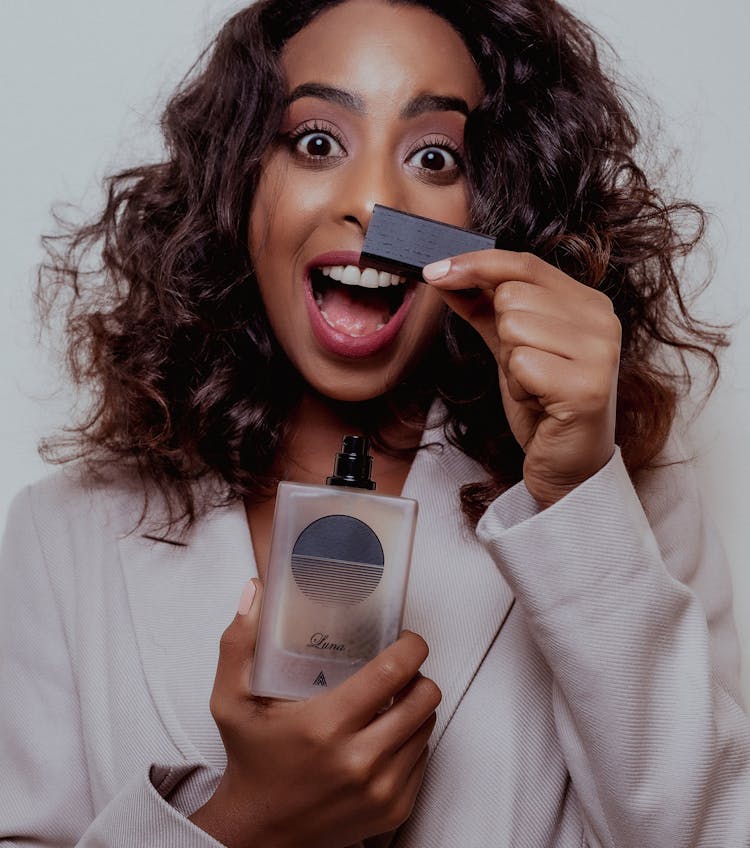 Excited Woman Holding A Bottle Of Perfume 