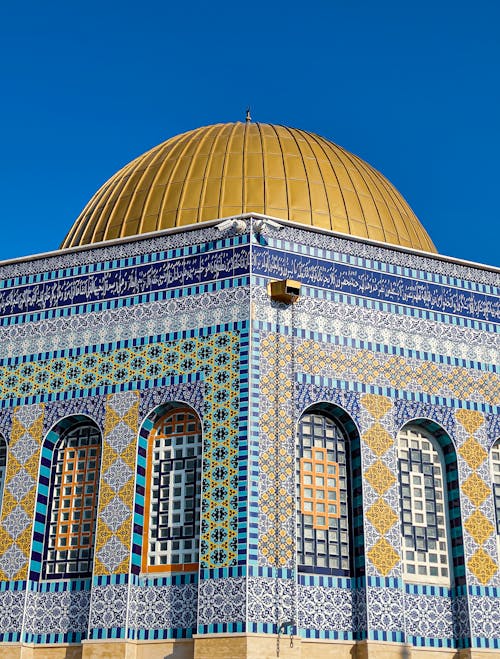 Facade of a Mosaic Building with Golden Cupola against Blue Sky