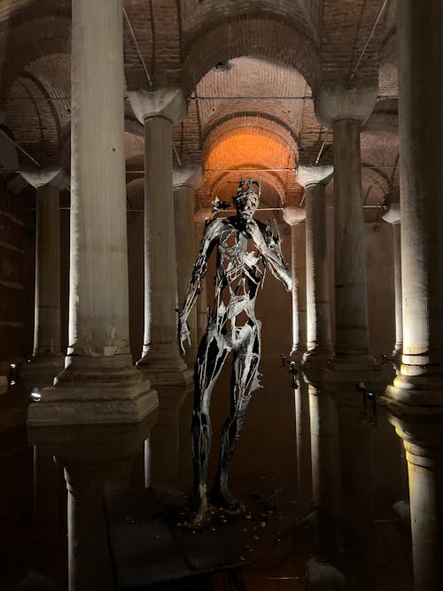 Spooky Metal Sculpture in a Cistern Interior with Arches and Columns