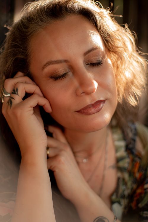 Free Close-up portrait of a woman with closed eyes, enjoying a moment of peace in soft, warm light. Stock Photo