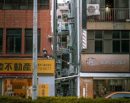 An urban street featuring commercial buildings with signs in an Asian cityscape, showcasing city life.