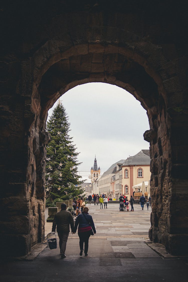 People Walking Beside The Stone Wall