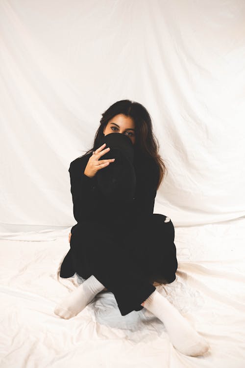 Free A Woman Covering her Face with a Black Cap Stock Photo