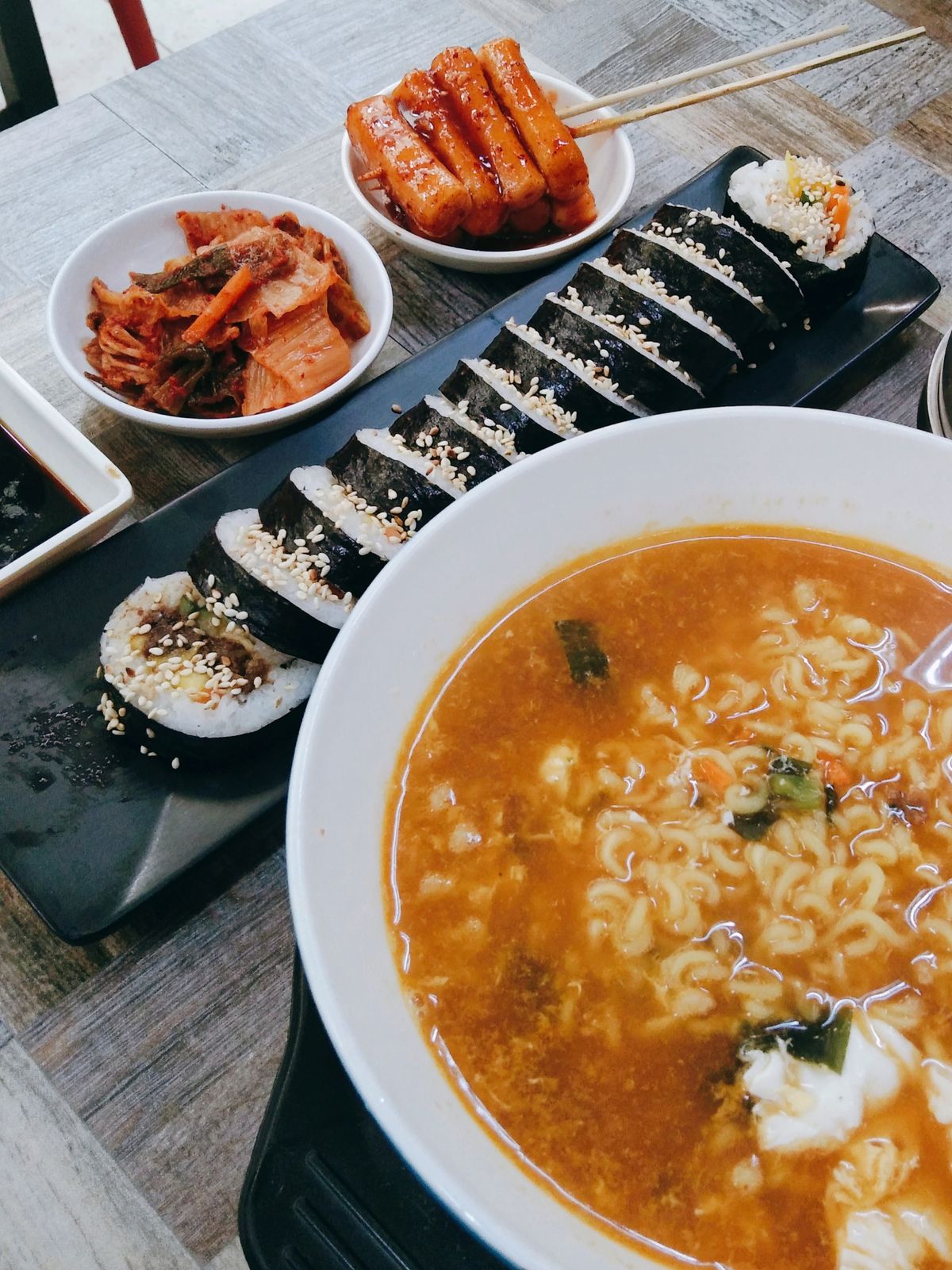 Gimbap rolls alongside noodles and side dishes