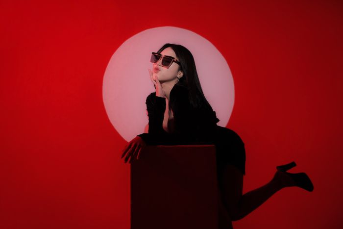 Portrait against a bold red studio backdrop — yusuf zainulhaq on Pexels