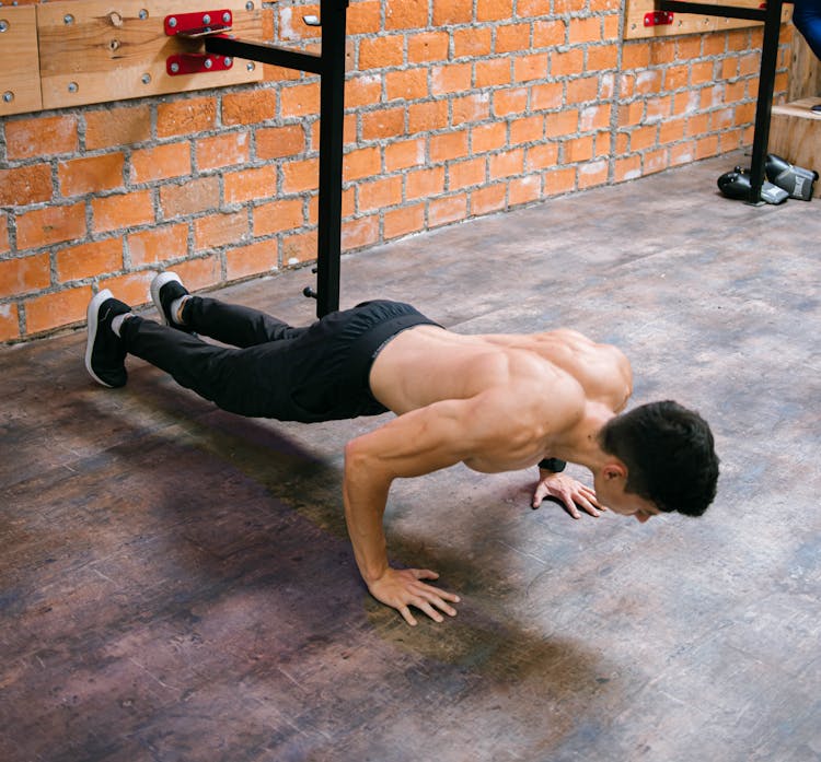 A Shirtless Man Doing Push Ups 