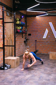 Woman exercising indoors in a stylish gym, focusing on strength training and fitness.
