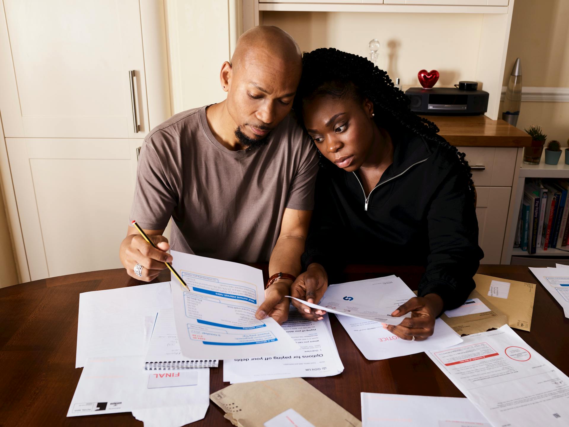 Couple Sitting by Table Looking through Bills