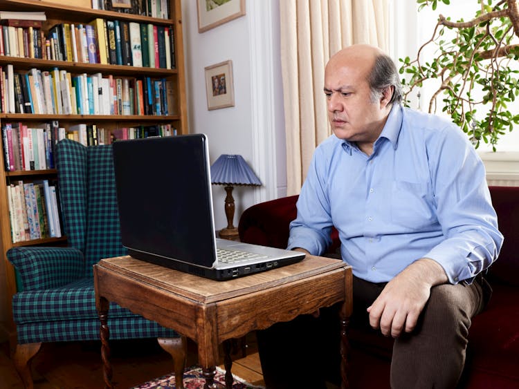 Man Sitting In Office Using Laptop