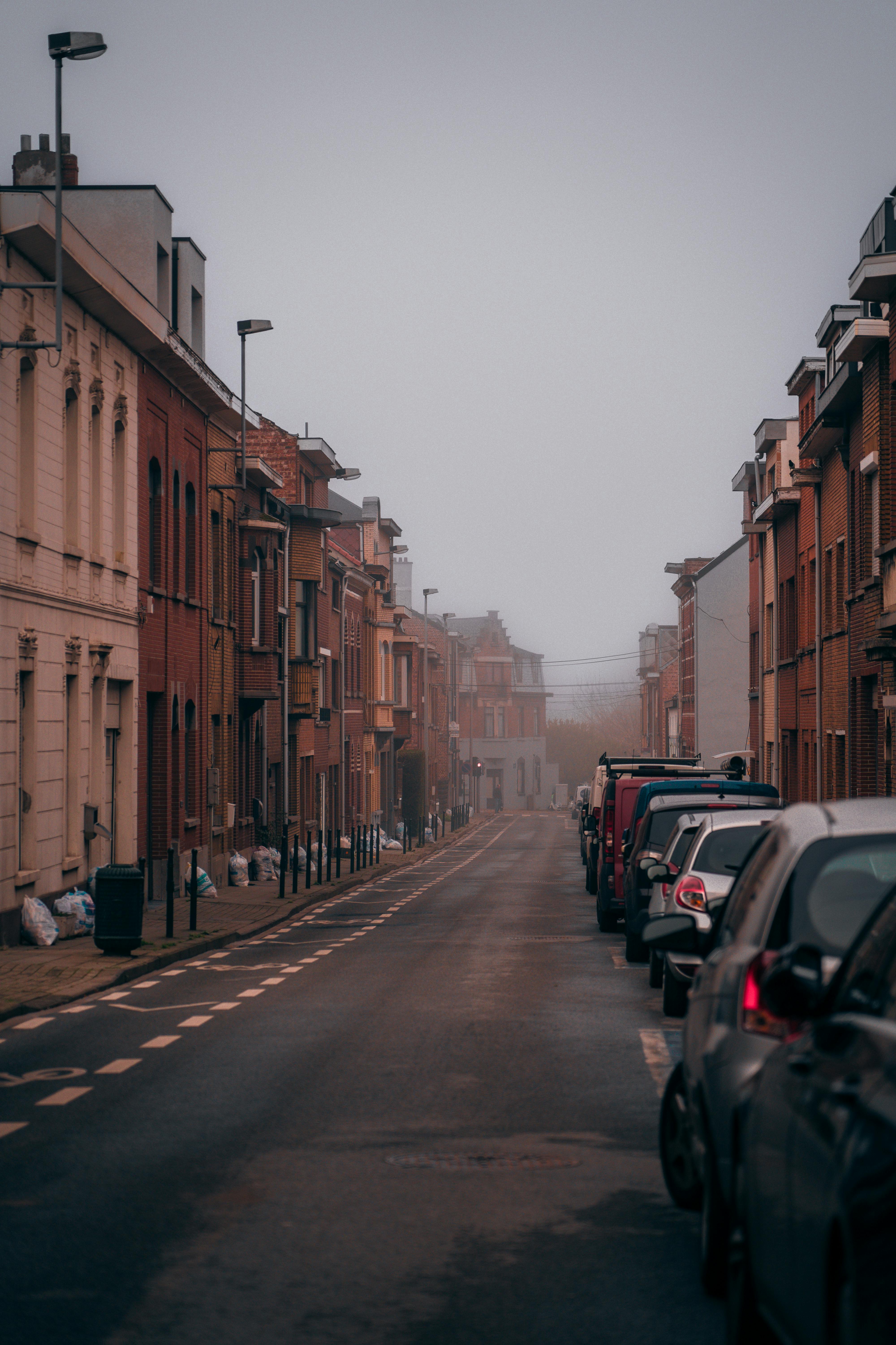 Black and White Photo of a Woman Walking down the Street in Misty ...