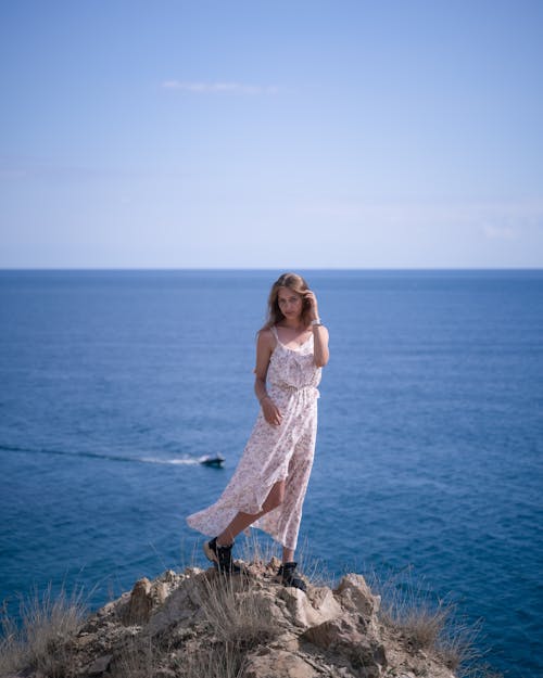 Woman in White Dress standing on a Cliff