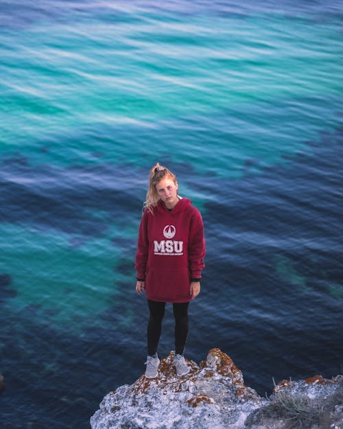 Frau, Die Auf Dem Felsen Am Meer Steht