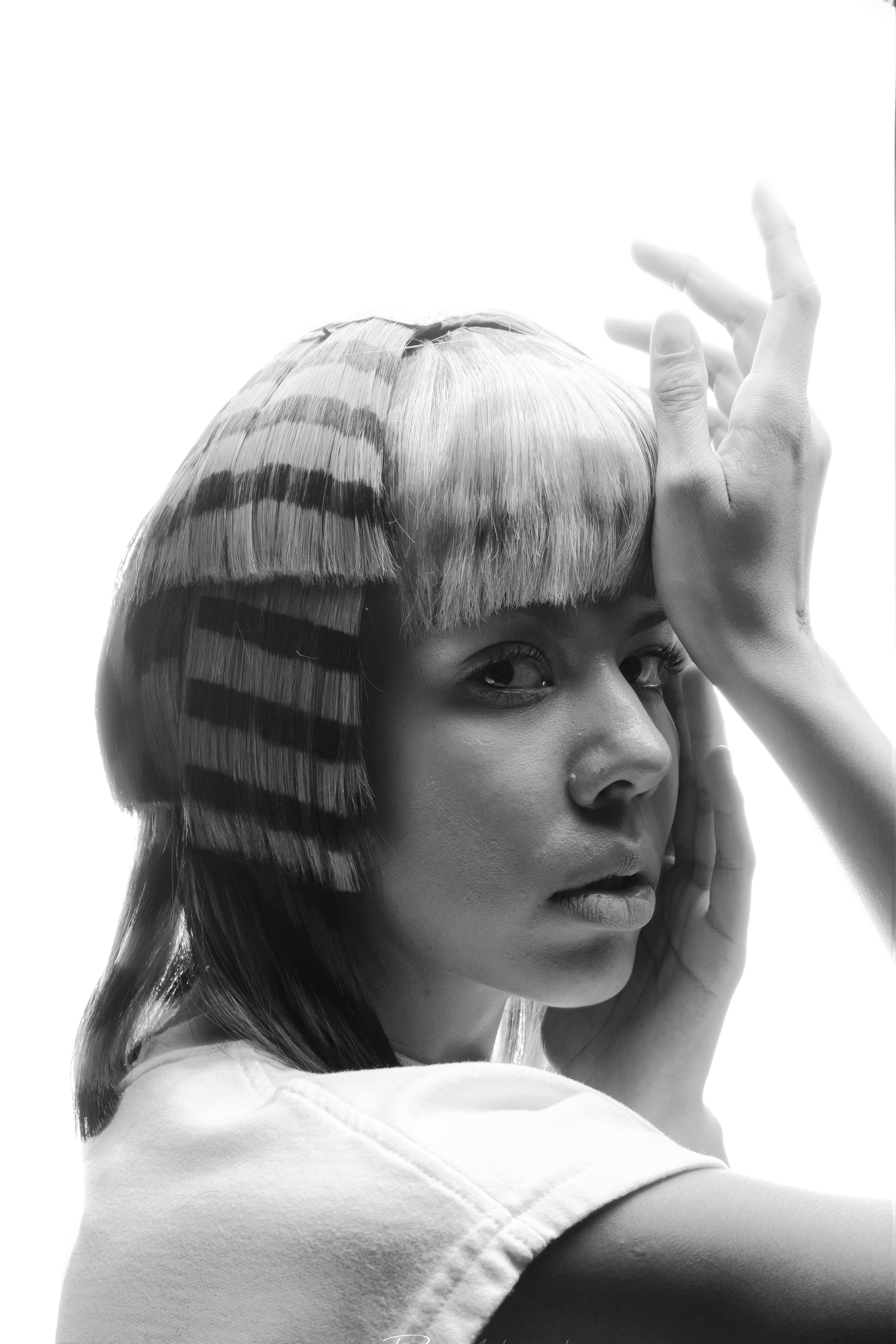 Fotomural Retrato elegante en blanco y negro de una mujer con cabello a rayas único y una expresión reflexiva.