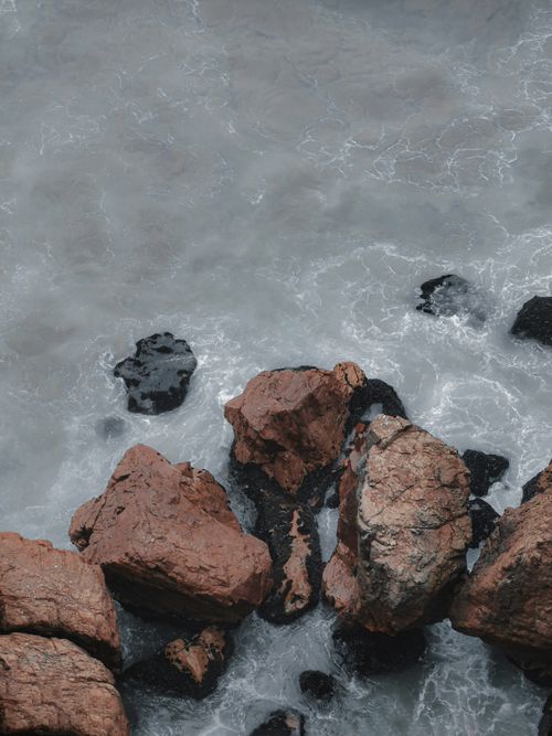 Free A stunning view of coastal rocks with ocean waves crashing against them. Stock Photo