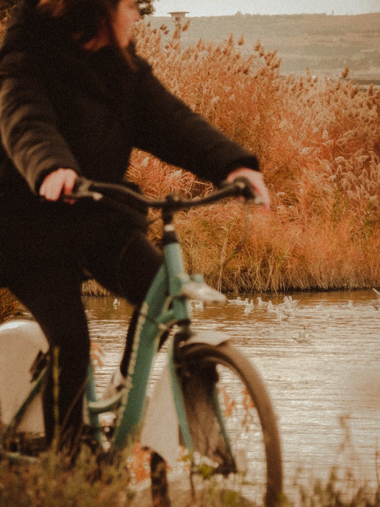 Woman Cycling Near Water