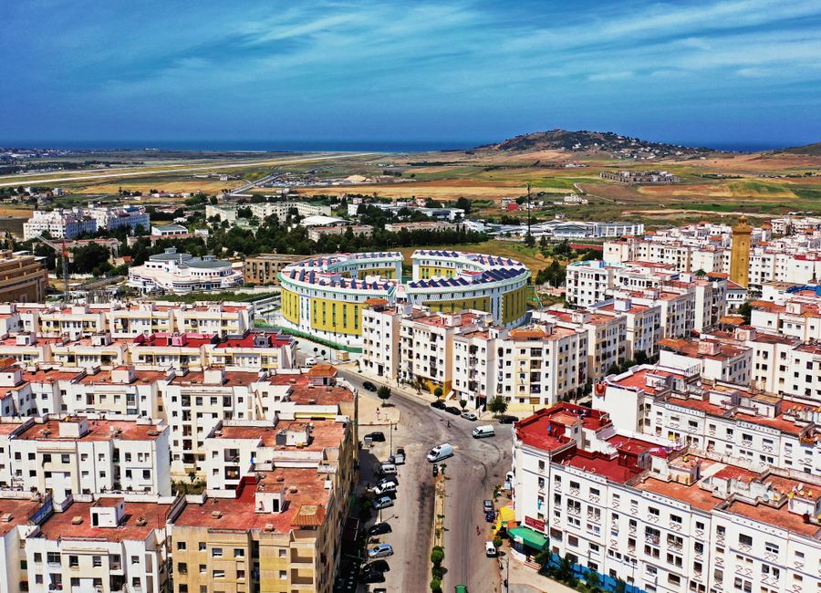 Drone shot of Tanger cityscape, residential buildings, and coastal view in Morocco.