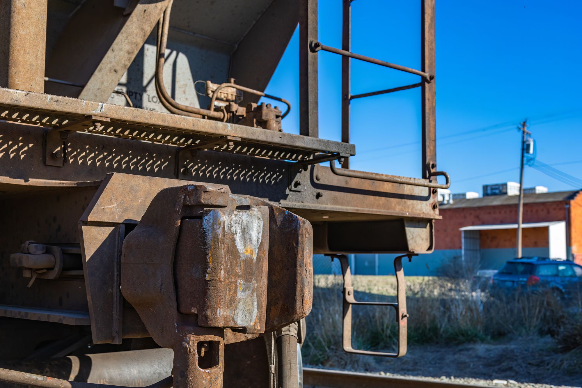 Close-up of a weathered railcar coupler and end platform on a freight car