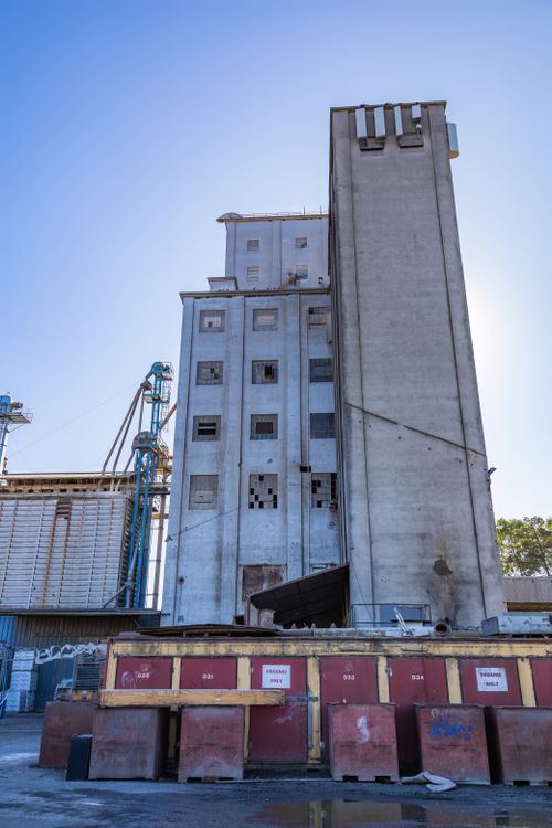 Free Vertical shot of an abandoned industrial building with a clear blue sky, showcasing urban decay. Stock Photo