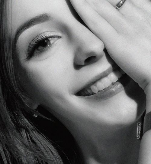 Free Smiling woman covering one eye with hand, showing happiness in grayscale portrait. Stock Photo