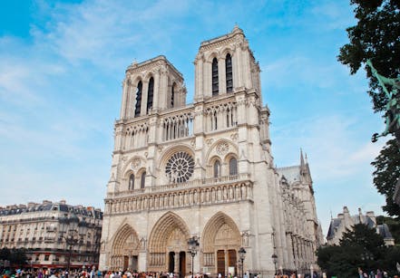 Architectural beauty of Notre Dame Cathedral with crowds in Paris, France.