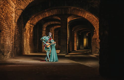 Bard in Face Mask Playing Lute in Empty Castle Halls