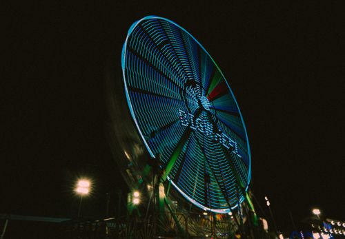 Free A vibrant Ferris wheel illuminated at night, capturing the essence of a city carnival. Stock Photo