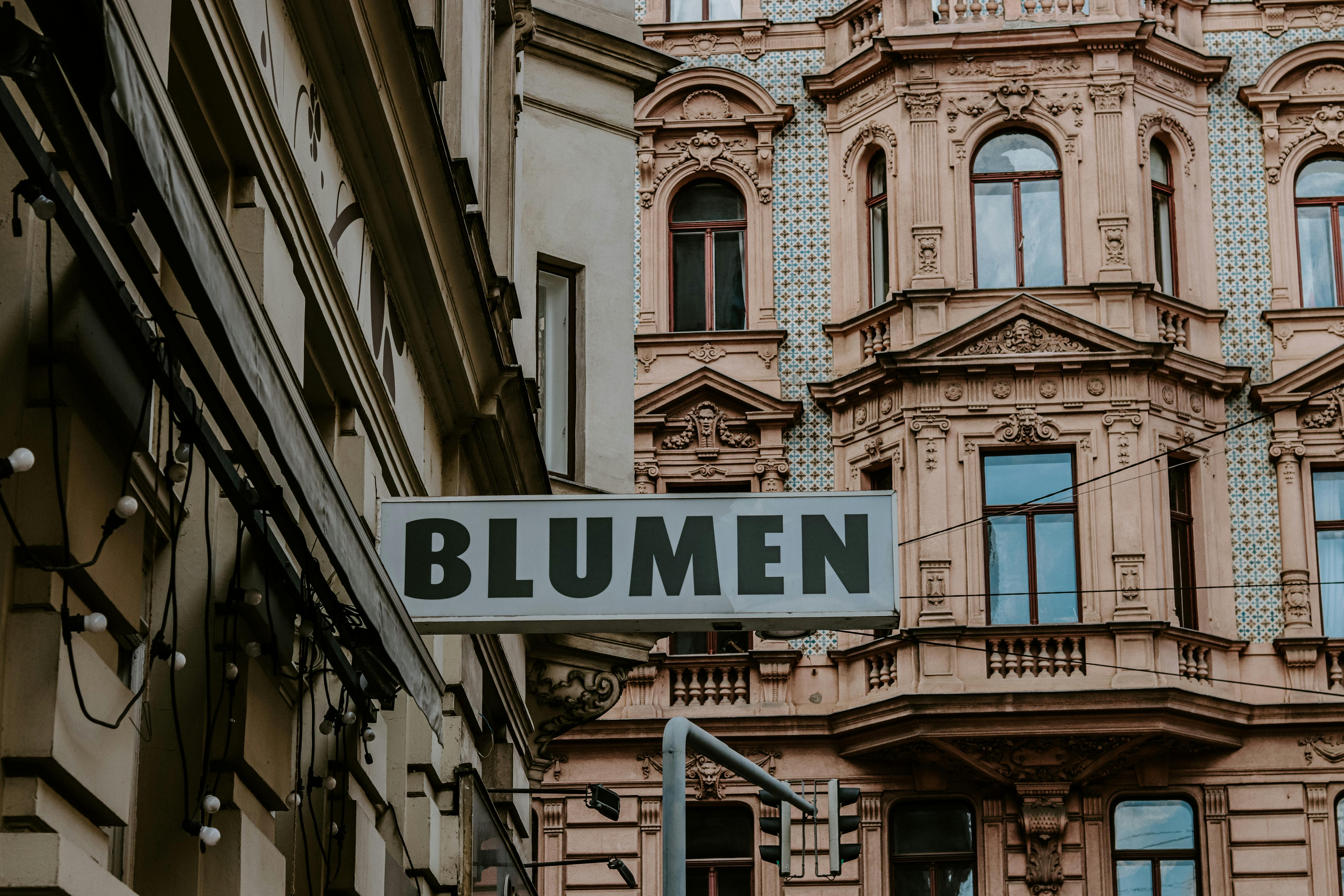Intricately detailed historic building facade with a 'Blumen' sign in an urban setting.