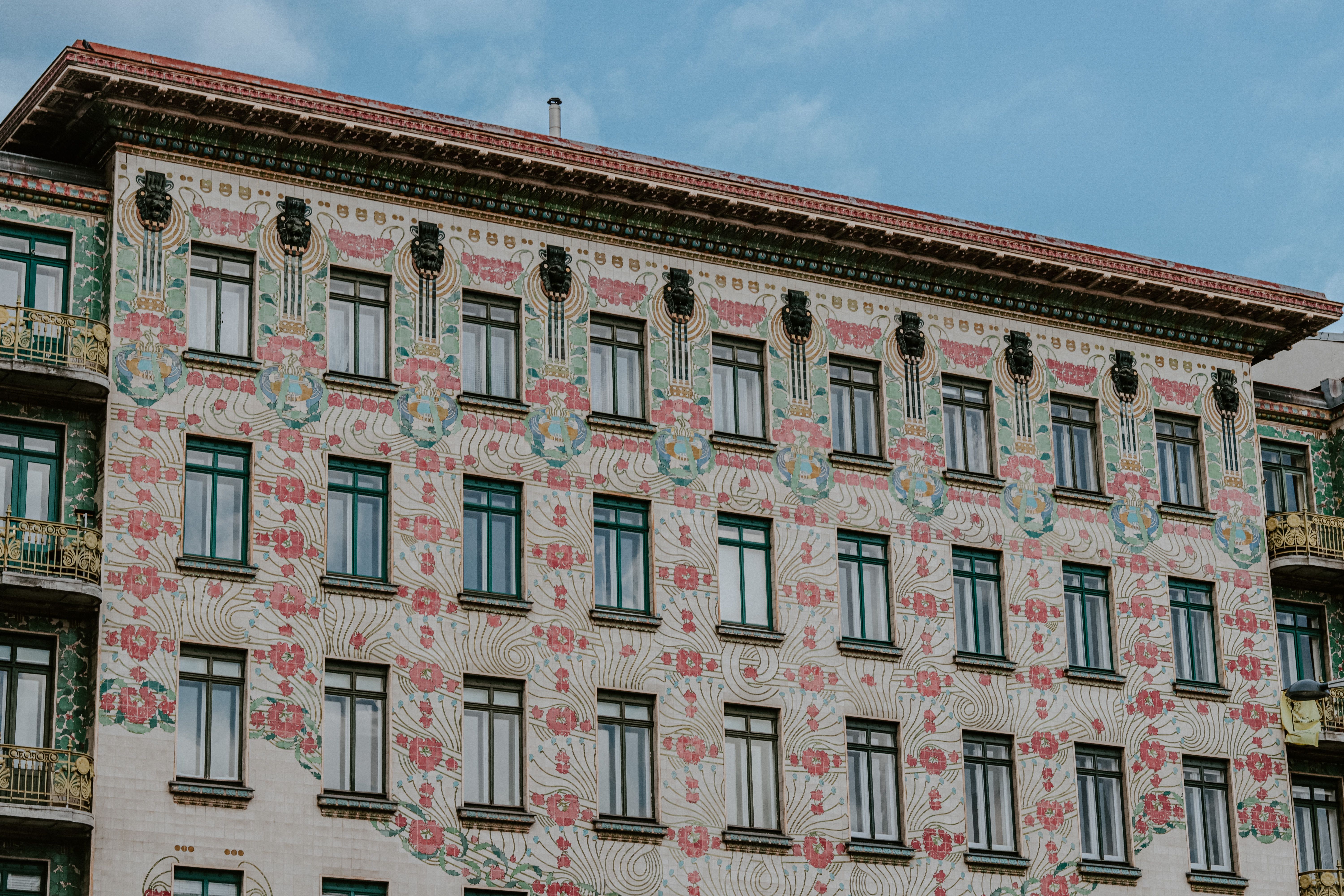 Detailed view of a colorful building facade featuring ornate Art Nouveau designs and floral motifs.. pexels, detailed, view