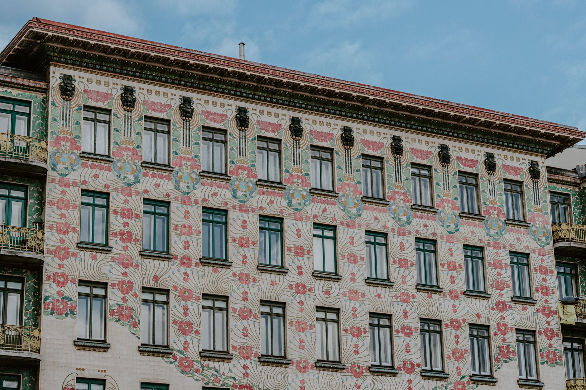 Detailed view of a colorful building facade featuring ornate Art Nouveau designs and floral motifs.. pexels, detailed, view