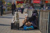 A senior street vendor selling goods on a sunny day in Sulaymaniyah, Iraq.