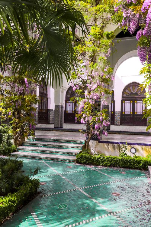 A courtyard with green tiles and purple flowers · Free Stock Photo