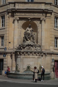 A detailed view of the A. Georges Cuvier statue in Paris, featuring intricate sculptures and urban surroundings.