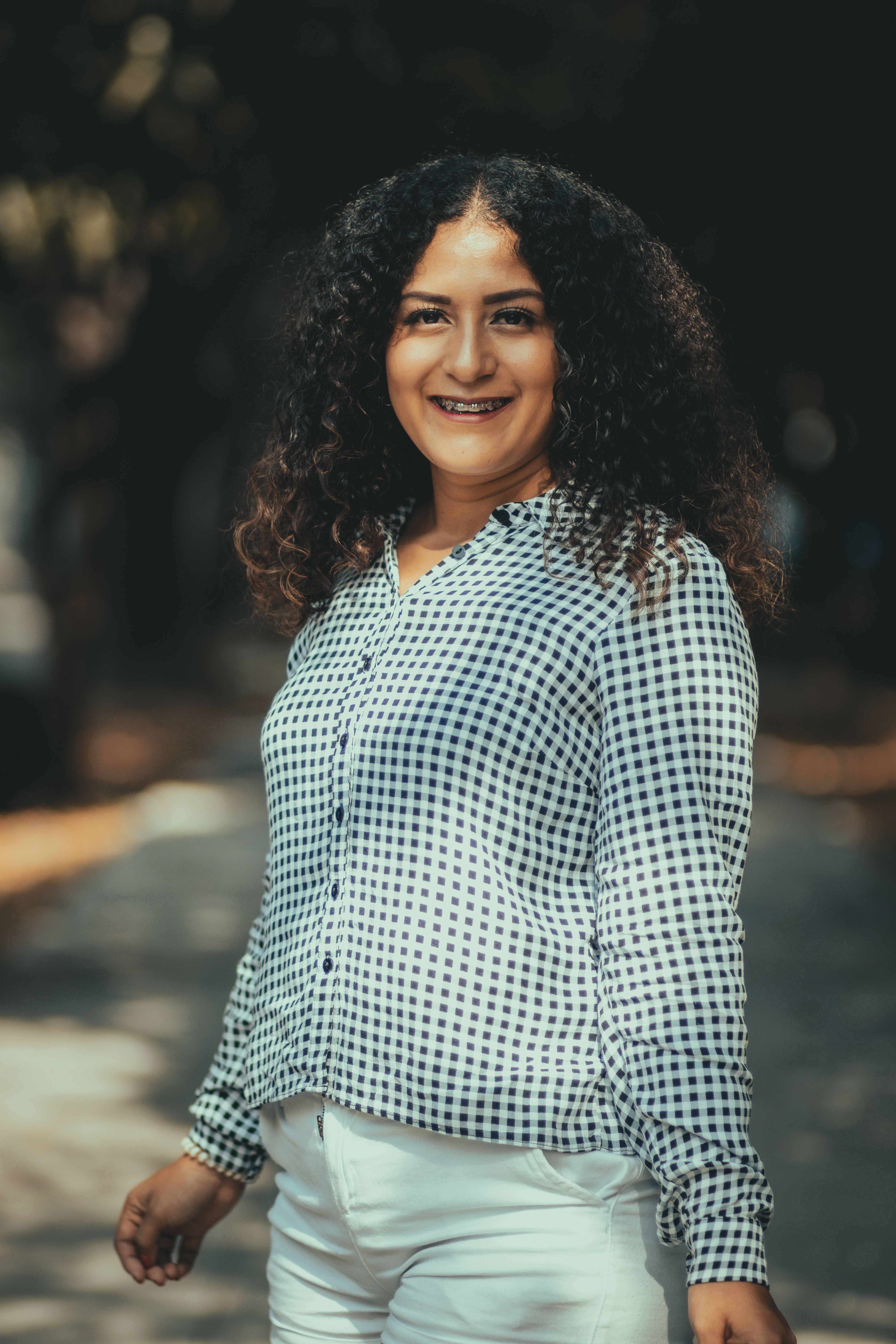 Portrait of a joyful woman with curly hair, outdoor scene