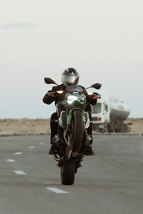 A Person Riding Black and Green Motorcycle