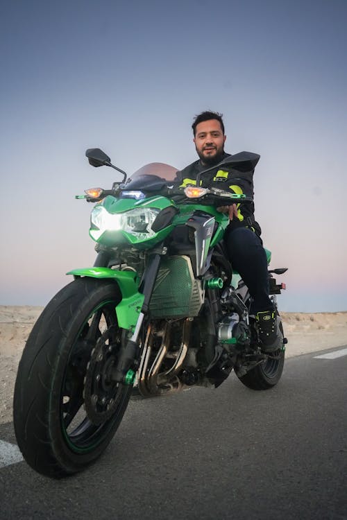 Man Riding on Green and Black Motorbike