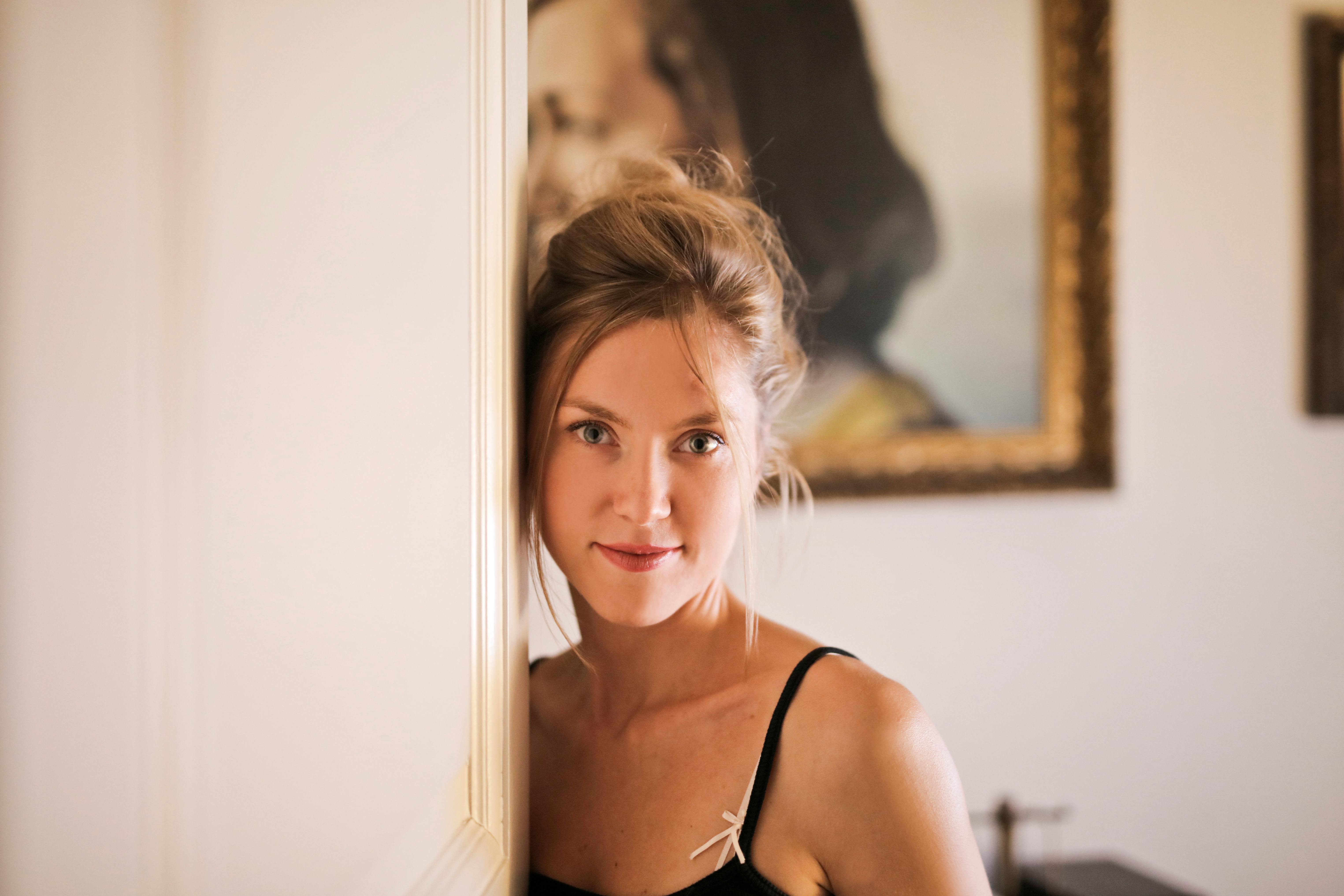 woman leaning on white wall