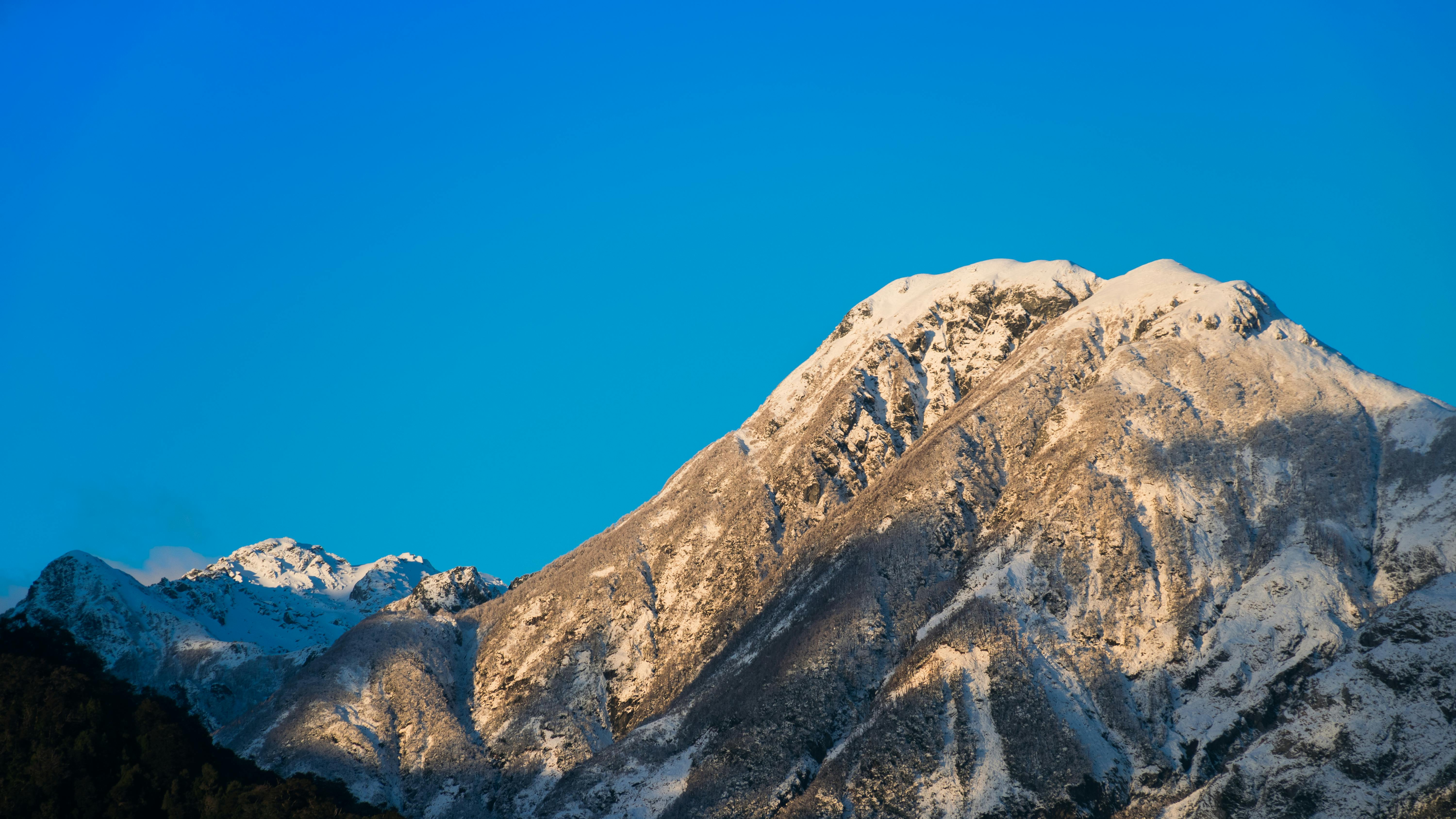 Breathtaking view of a snowcapped mountain peak in Chaiten, Chile under a clear blue sky.