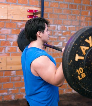 An adult male lifting a barbell in an indoor gym in Mexico City.
