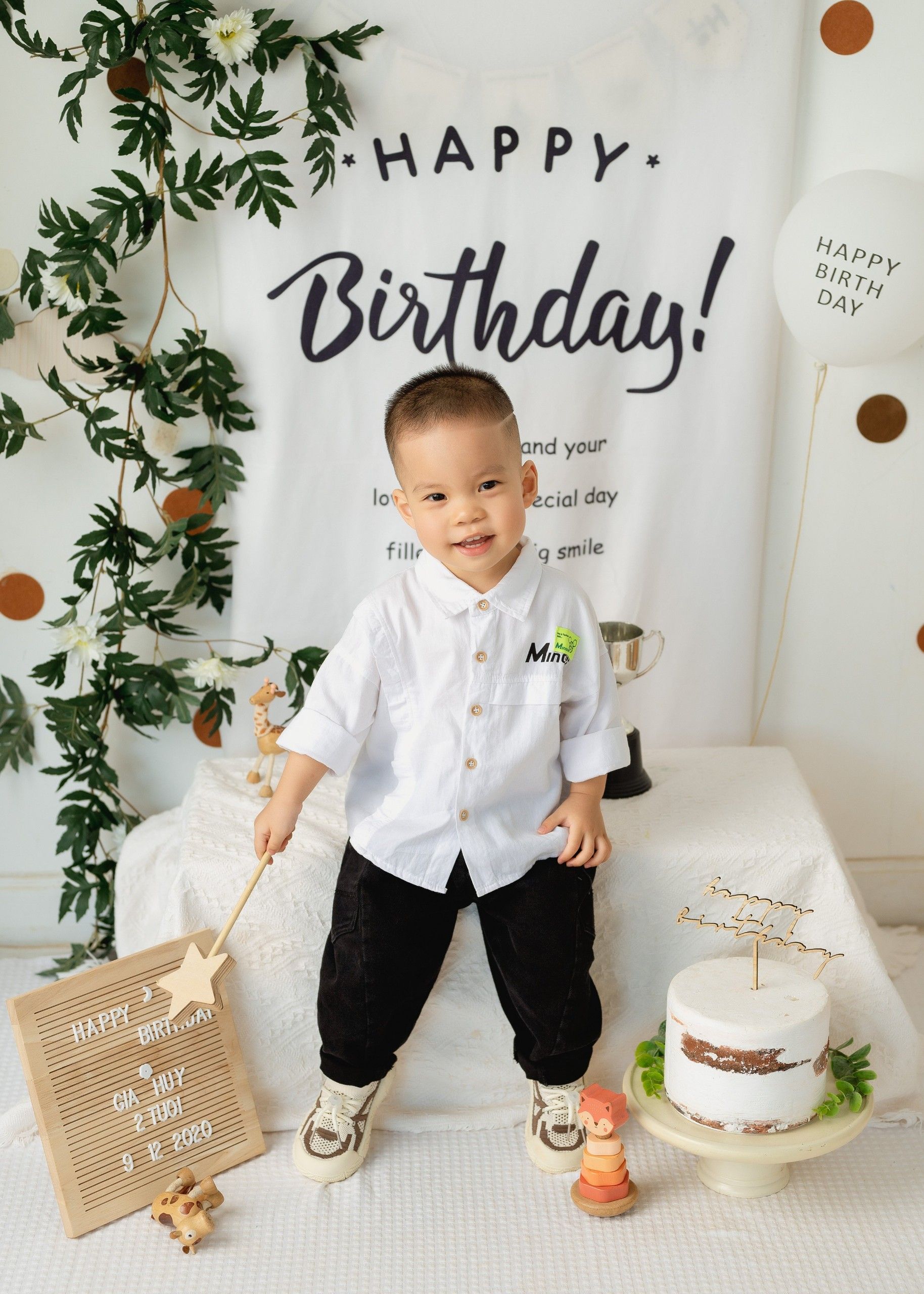 Cheerful toddler enjoying a birthday party with cake and decorations in Ho Chi Minh City.