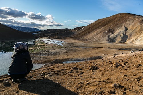 Ücretsiz Kahverengi Dağın önünde çömelen Kişi Stok Fotoğraflar