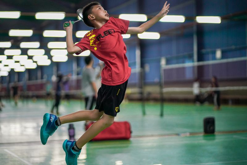 Badminton players rallying on an indoor court