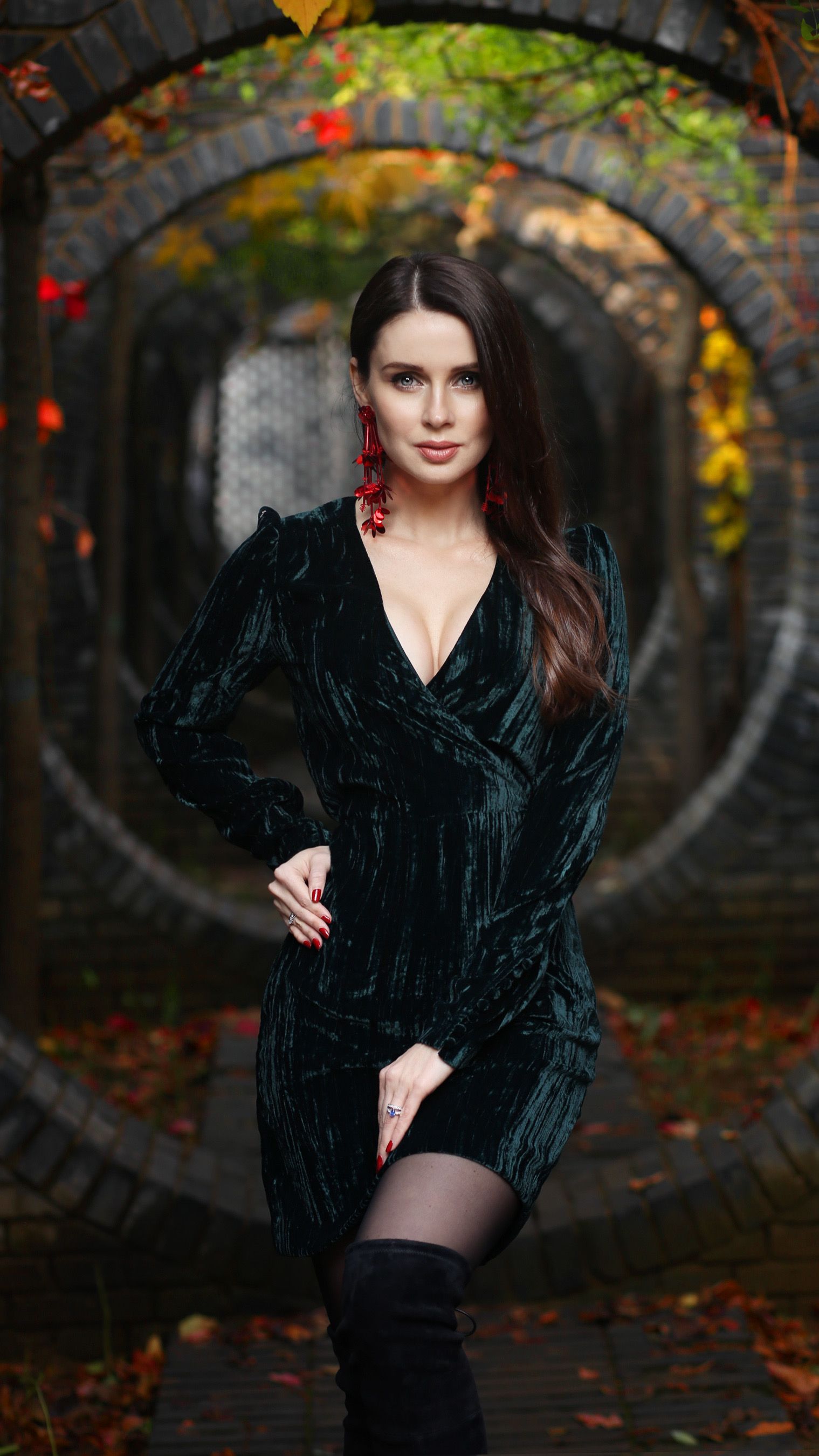 woman in emerald velvet midi dress with black heeled booties