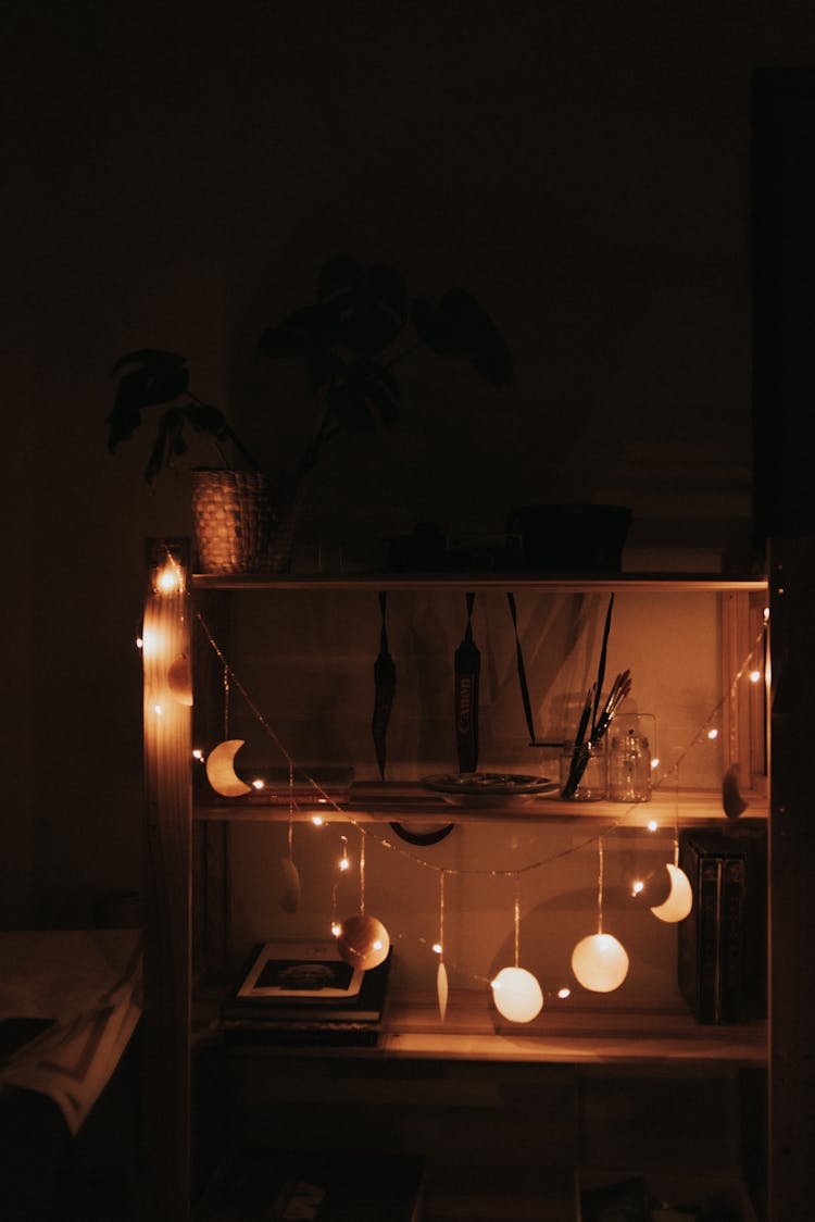 String Lights In The Shape Of Moon And Stars Hanging From A Shelf 